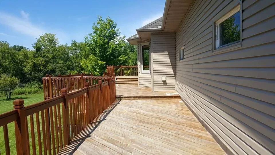Stained wood deck with custom railings overlooking landscaped yard