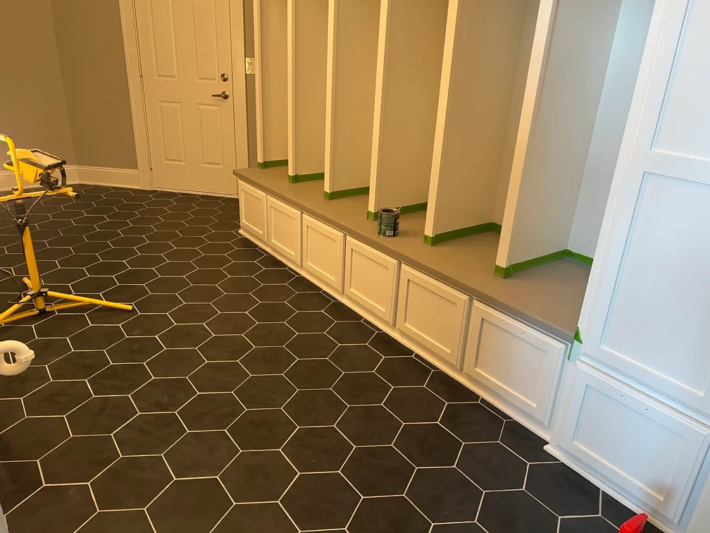 Interior room with freshly painted walls, white trim, wainscoting, and hexagonal tile flooring