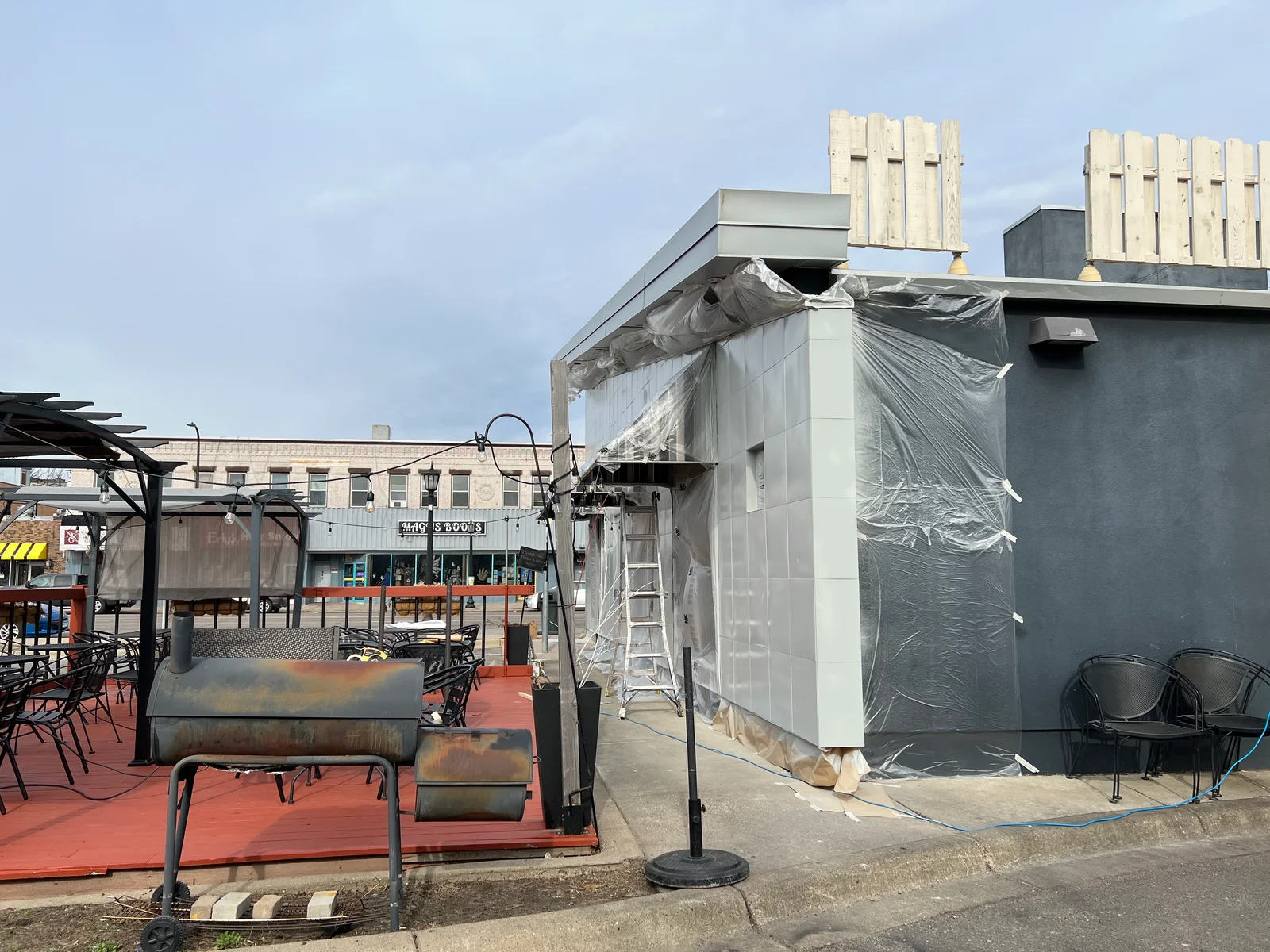 White and gray painted rooftop mechanical enclosure with metal siding and protective plastic sheeting