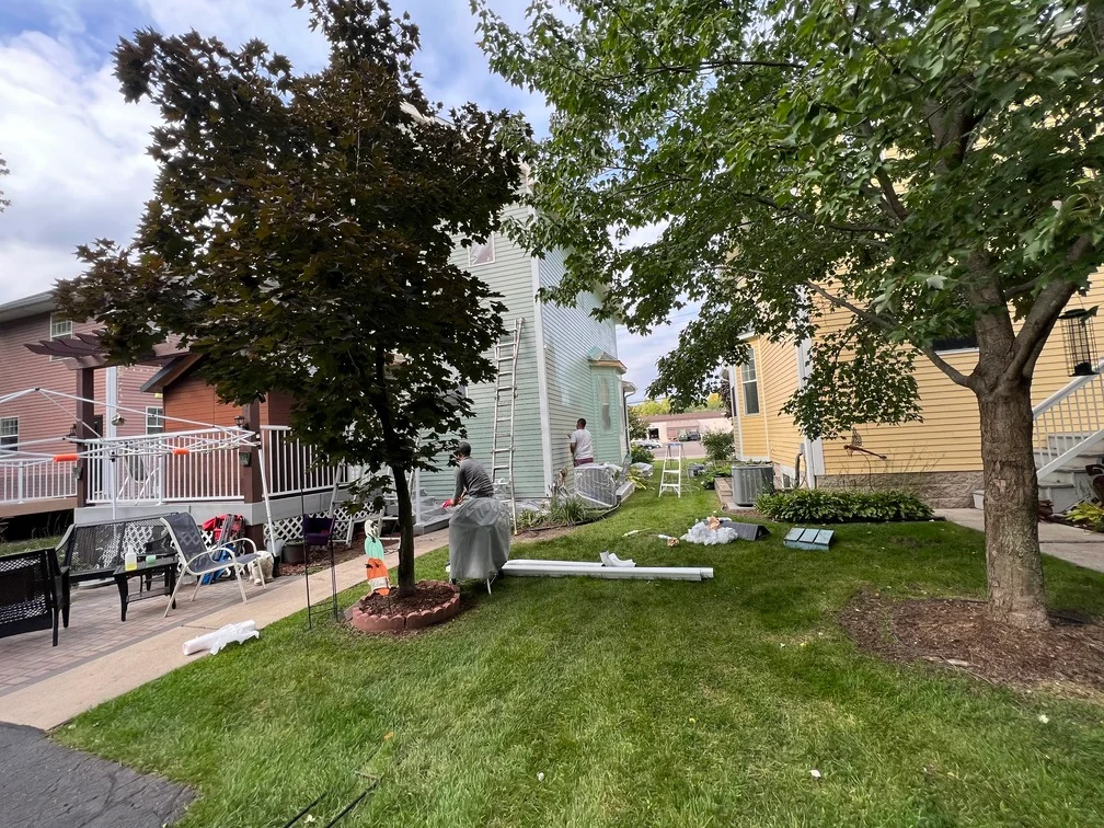 Freshly painted light green residential home exterior with white trim and siding