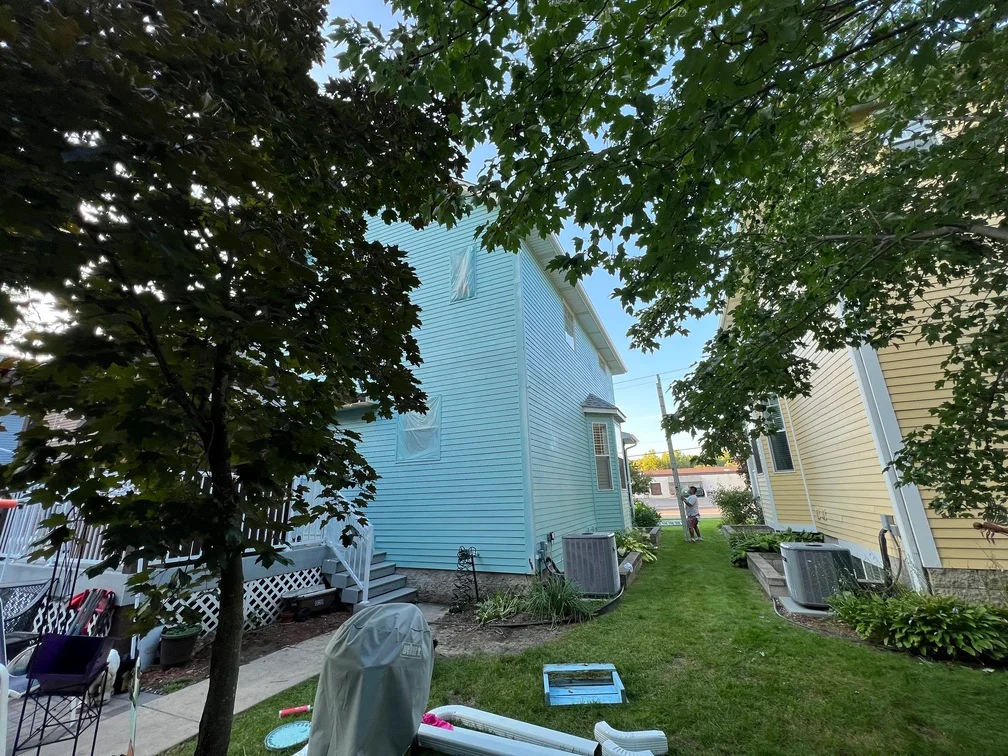 Light blue painted house with horizontal siding, white trim, and lattice foundation details