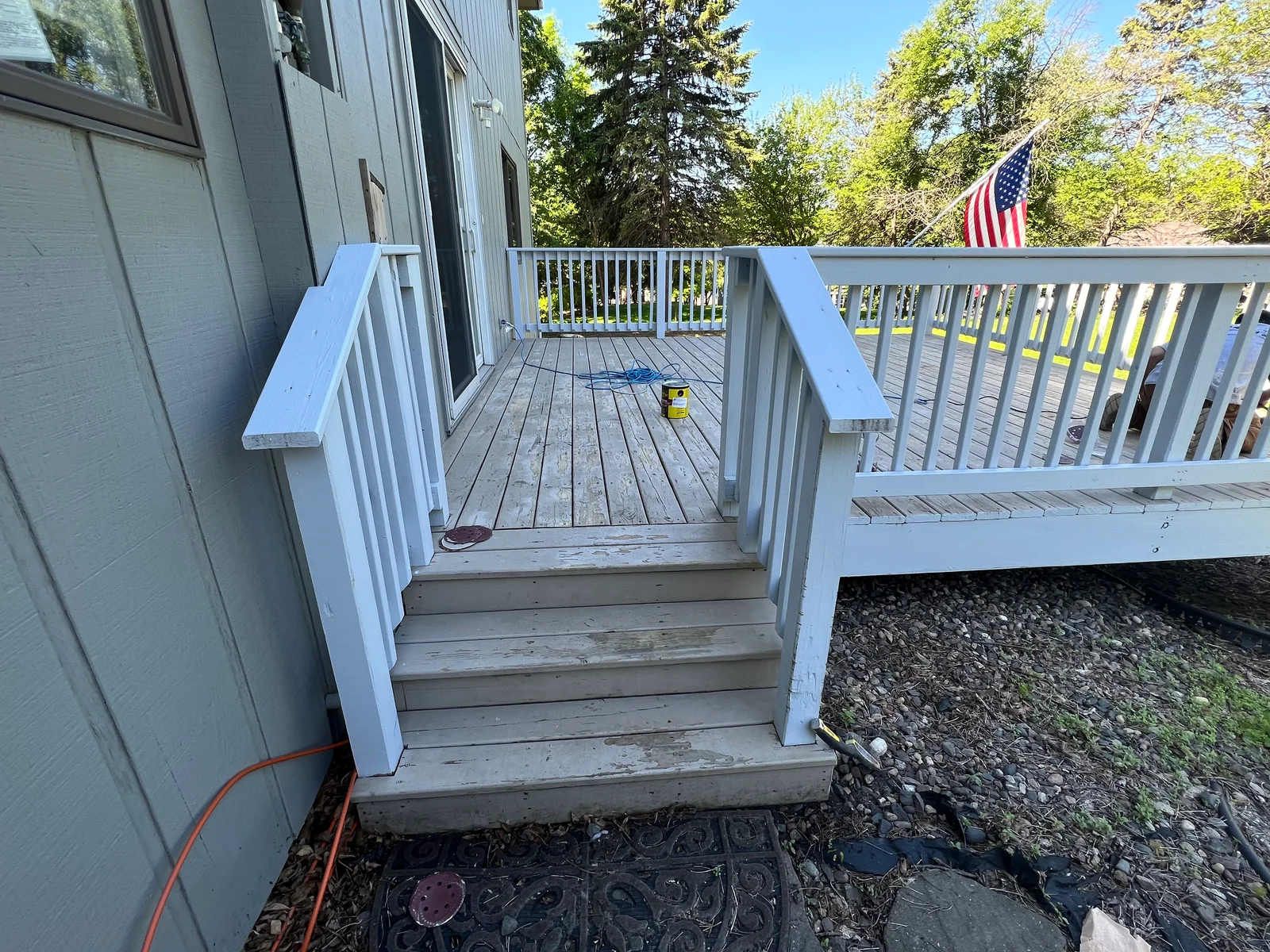 White painted deck railings and trim on multi-level wooden deck with stairs