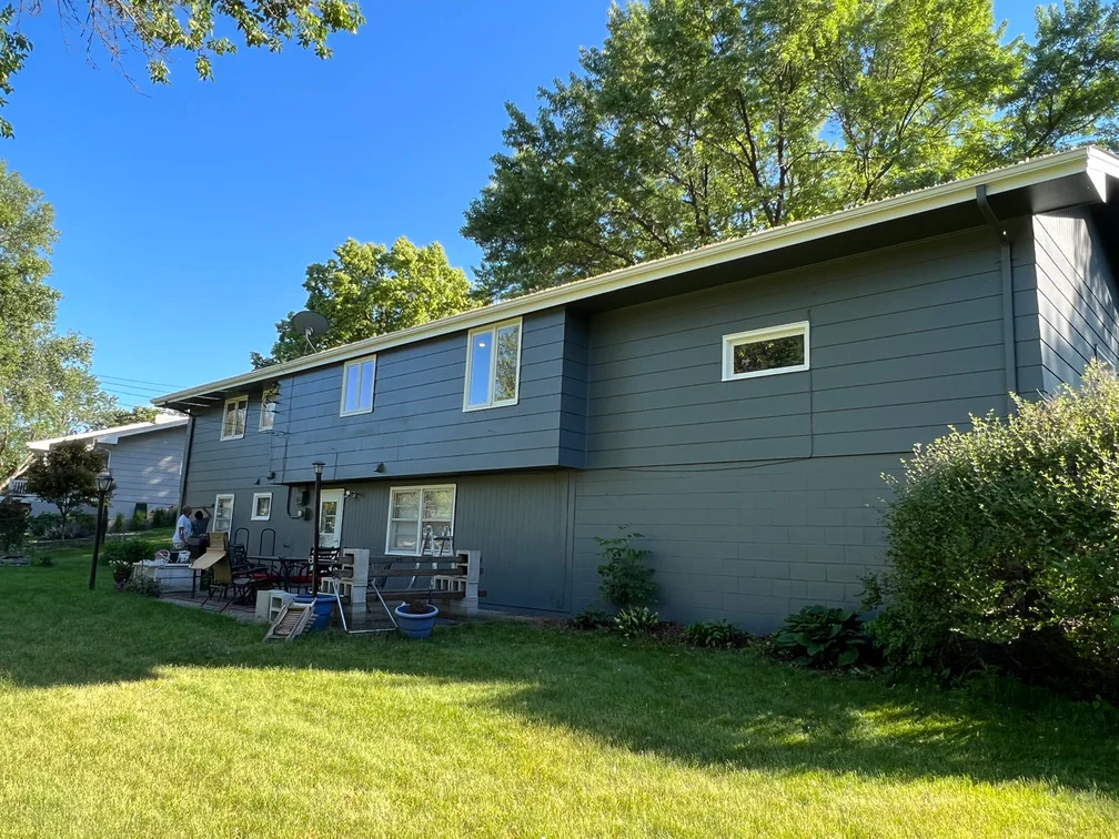 Two-story home with freshly painted blue-gray horizontal siding and white trim