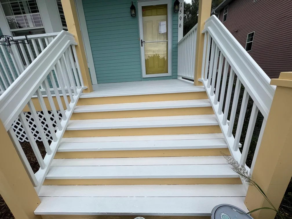 White and tan painted composite deck with white vinyl railings and lattice panels