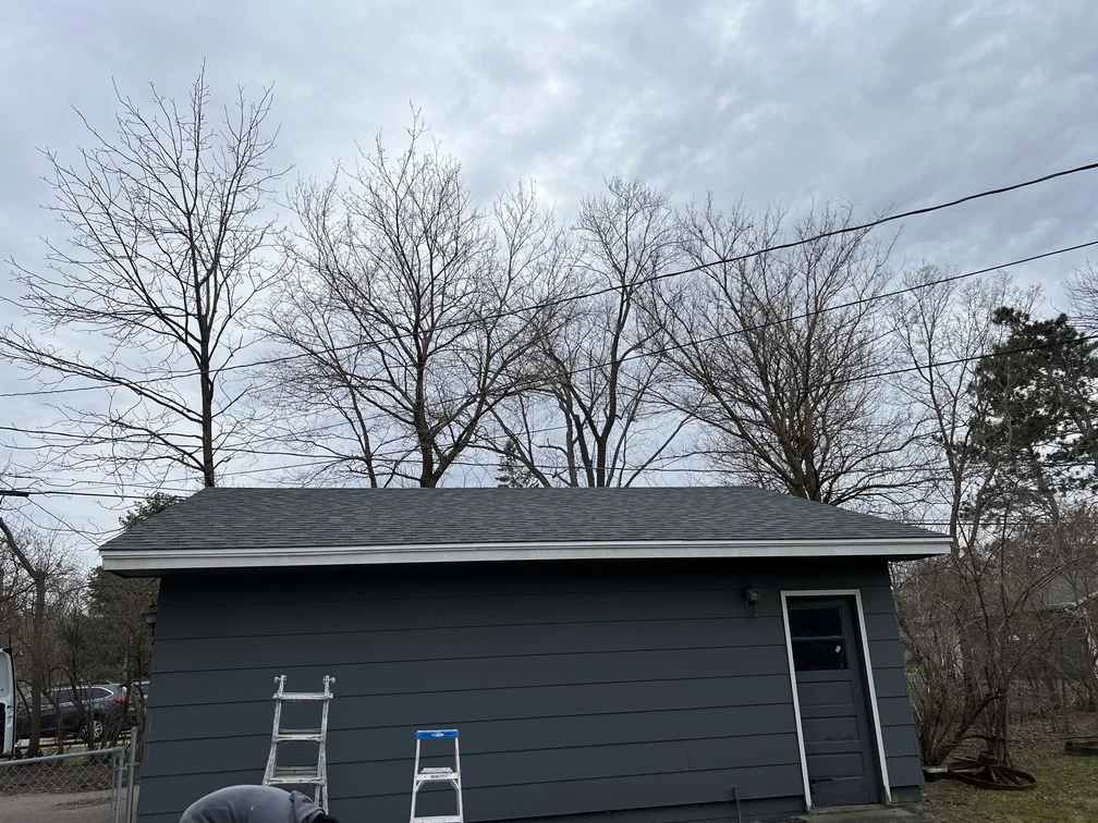 Charcoal gray painted garage with horizontal siding and gray roof