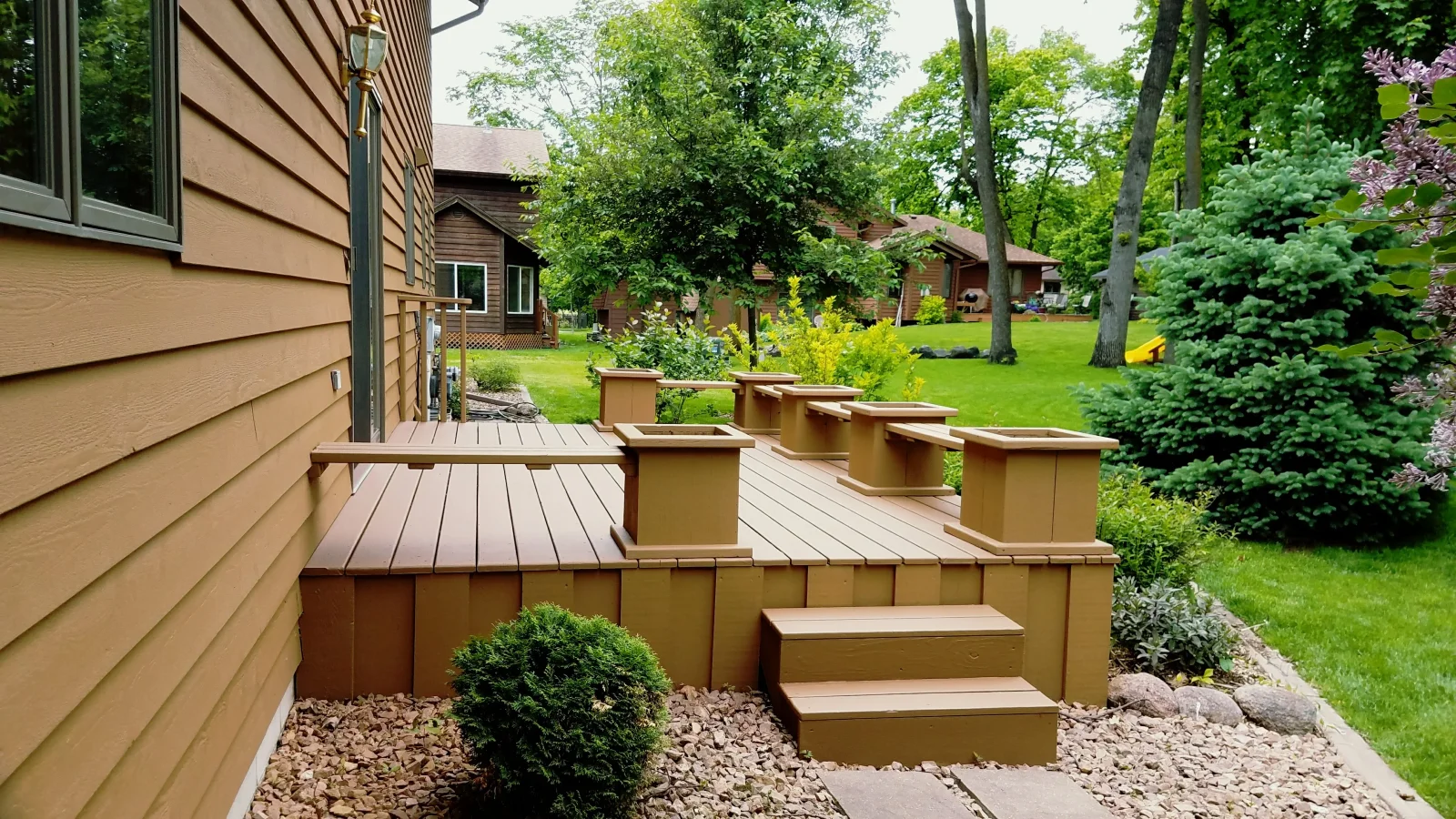 Multi-level composite deck with built-in planter boxes and metal-capped railings