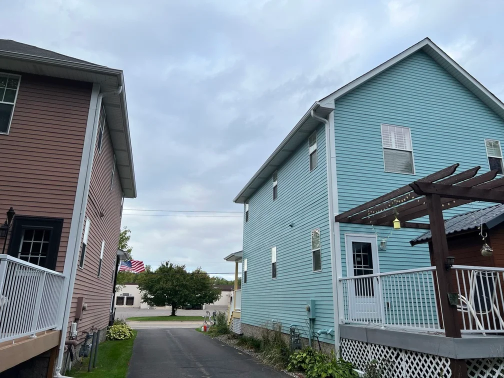 Two-story house with light blue fiber cement siding and white trim, freshly painted exterior
