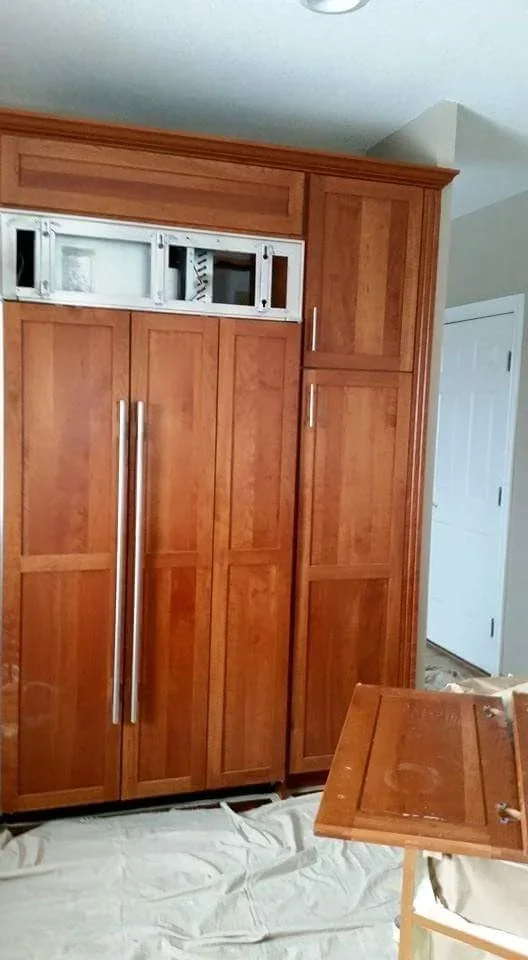 Custom wood cabinetry with rich stain finish, multiple panel doors, and chrome hardware