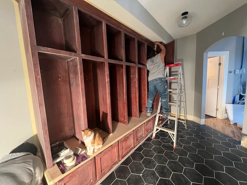 Burgundy stained custom built-in cabinetry with glass doors and detailed trim work