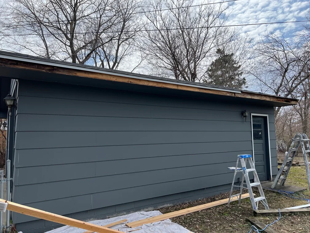 Dark gray painted garage exterior with horizontal siding and matching door